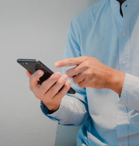 Person interacting with smartphone, emphasizing mobile responsiveness and user engagement in web design.