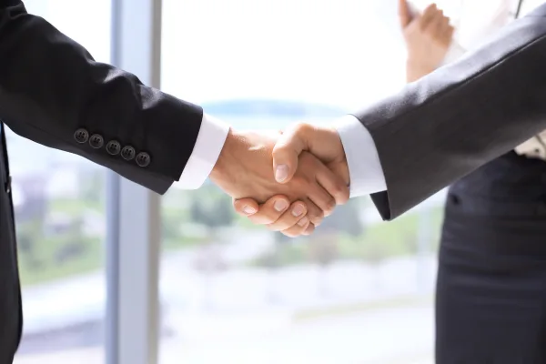 Business professionals shaking hands, symbolizing partnership and collaboration in web design and SEO services.